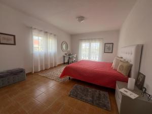 a bedroom with a red bed with a red blanket at Casa Amar in Loulé +19 photos