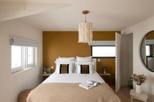 a bedroom with a large white bed and a mirror at MAISON V AU COEUR DU VILLAGE Alpilles in Maussane-les-Alpilles