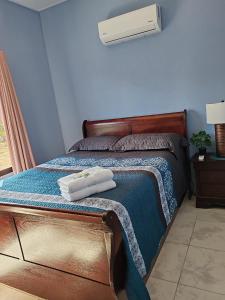 1 dormitorio con 1 cama con toallas en Casa Hortensia, en Nicoya