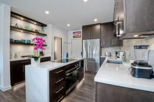 a kitchen with brown cabinets and white counter tops at La Costa Luxury Condo - Fully Remodeled in Encinitas