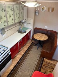 eine Küche mit einem Tisch, einem Waschbecken und einem Tisch in der Unterkunft Отель "Natali" in Mykolajiw