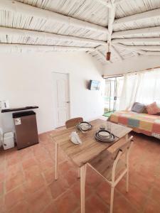 a living room with a wooden table and a bed at Oasis de Vichayito in Vichayito