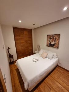a bedroom with a white bed with a tiger painting on the wall at House of Zoo in Lisbon