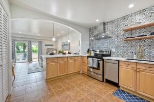 a kitchen with wooden cabinets and a stove top oven at La Costa Escape - Pool, BBQ, Gated Parking in Encinitas