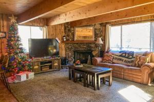 uma sala de estar com uma árvore de Natal e uma televisão em The Woodsy Whimsical Cabin em Big Bear Lake