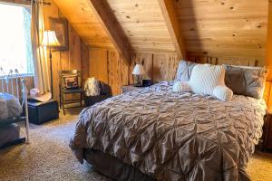 um quarto com uma cama grande num chalé de madeira em The Woodsy Whimsical Cabin em Big Bear Lake