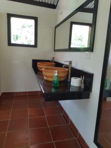 une salle de bain avec un comptoir avec deux lavabos et un miroir dans l'établissement Casa Altozano Hotel, à Fusagasuga