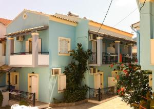 a blue house with white windows and balconies at Philippos Apartments in Acharavi