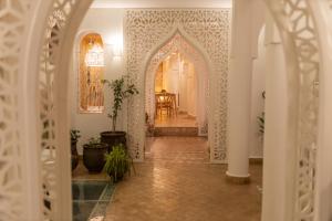 corridoio con arco e tavolo in una stanza di Riad Nila a Chefchaouen