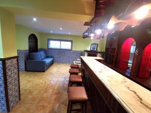 Nina23 - garagem gratuita في أفيرو: يوجد بار مع أريكة وكراسي في الغرفة