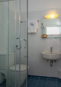 e bagno con doccia, servizi igienici e lavandino. di Aeolis Hotel ad Adámas