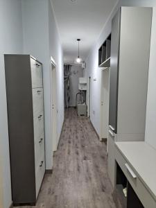 - un couloir avec des armoires blanches et du parquet dans l'établissement Welcome home, à Terni