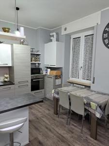 - une cuisine avec des placards blancs, une table et des chaises dans l'établissement Welcome home, à Terni