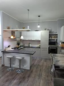une cuisine avec des placards blancs et un îlot avec des tabourets de bar dans l'établissement Welcome home, à Terni