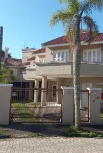 南聖洛倫索的住宿－Apartamento BLUE 04 - 100 metros da praia，一座带大门和棕榈树的房子
