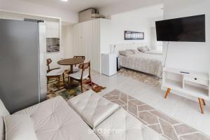 a living room with a couch and a bed and a table at Studio cond com piscina 180m hard rock café ESR1912 in Curitiba +24 photos