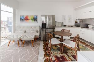 a living room with a table and chairs and a kitchen at Studio cond com piscina 180m hard rock café ESR1912 in Curitiba