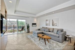 a living room with a couch and a table at Private Balcony Overlooking Pool - Gated Parking in Encinitas