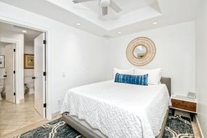 a white bedroom with a bed and a mirror at Private Balcony Overlooking Pool - Gated Parking in Encinitas +29 photos