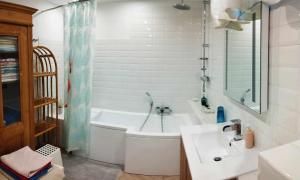 La salle de bains blanche est pourvue d'une baignoire et d'un lavabo. dans l'établissement B&B Family Basement Apartment, Breakfast, Free Parking, 5km from Tulln, à Chorherrn