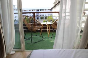Habitación con balcón con mesa y sillas. en L'oiseau du paradis - moderne et élégant en Cayenne