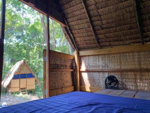 a large room with a bed in a straw hut at Coral Bay Resort in Koh Ta kiev Island