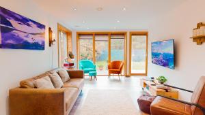 a living room with a couch and a chair at Woodhaus Aviemore Lodge in Aviemore