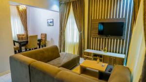 - un salon avec un canapé et une télévision dans l'établissement Two bedroom lux apartment, à Gwarinpa