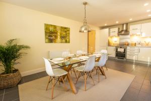 a dining room with a table and white chairs at The Wellness Lodge- Gym, Table Tennis, Cinema, Parking and more! in Bath