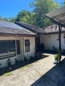 uma casa com um alpendre com vasos de plantas em frente em Hostal Pelluco em Llanquihue