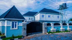 une maison bleue et blanche avec une porte noire dans l'établissement Two bedroom lux apartment, à Gwarinpa