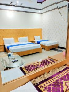 twee bedden in een kamer met een spiegel bij Hotel VIP Palace Lodge in Multan