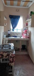 una piccola cucina con piano cottura e finestra di Lk home a Nanyuki