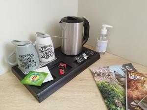 a tray with two cups and a coffee maker on a table at La Sarlamandre, Chambres et table d'Hôtes in Marcillac-Saint-Quentin