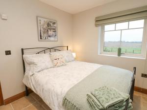 a bedroom with a bed and a window at Sutton Newbold Cottage in Trimdon Grange