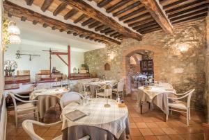 un restaurante con mesas y sillas en una habitación en Mulino Di Quercegrossa, en Quercegrossa