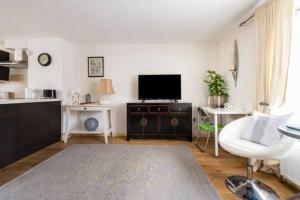 a living room with a flat screen tv and a couch at Super Central beautiful 3 Bedroom in London