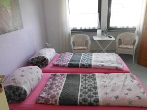 twee bedden in een slaapkamer met een tafel en stoelen bij Pension Sonnenschein in Schmallenberg