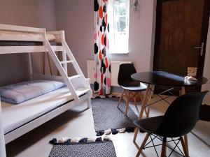 ein Schlafzimmer mit Etagenbetten sowie einem Tisch und Stühlen in der Unterkunft Sleeptide in Husum