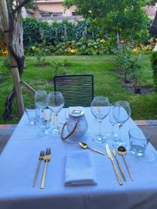 una mesa con copas de vino y utensilios. en Casa Vidal Guesthouse en Tupungato