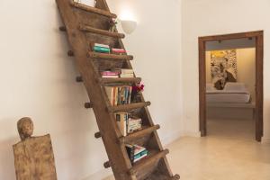 un estante de libros con libros al lado de un espejo en Bamboo House B&B, en Malindi