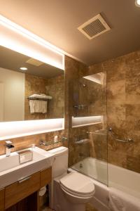 a bathroom with a toilet and a sink and a shower at Grotto Bay Beach Resort in Tuckerʼs Town