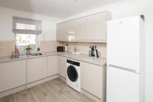 a kitchen with white cabinets and a washer and dryer at Entire Home, 2 Bedrooms - Private with FREE PARKING in Oxford in Oxford