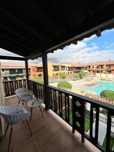 聖米格爾德阿沃納的住宿－San Blas Golf del Sur Residence，阳台配有两把椅子,享有游泳池的景色