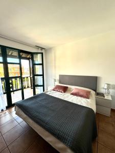 a bedroom with a large bed with two pink pillows at San Blas Golf del Sur Residence in San Miguel de Abona