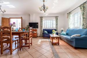 sala de estar con sofá azul y mesa en Villa Exotica, en Nerja