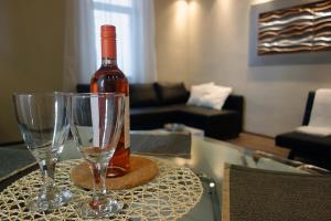 ブダペストにあるVivid Csengery Apartmentのワイングラス2杯付きのテーブルに座ったワイン1本