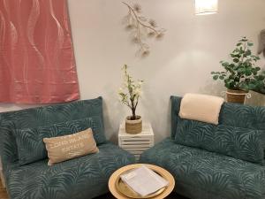 ein Wohnzimmer mit 2 grünen Sofas und einem Tisch in der Unterkunft The Corner Properties in Noirmoutier-en-l'lle