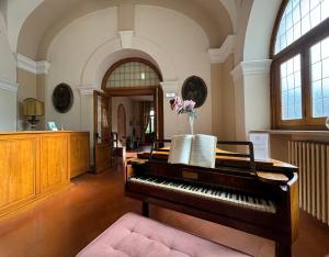 ein Klavier mit einer Blumenvase darüber in der Unterkunft Monastero SS. Annunziata in Todi