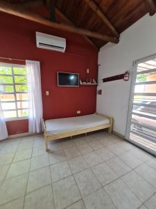 a room with a bench and a tv on a wall at LAS MARIAS - CHAJARI in Chajarí